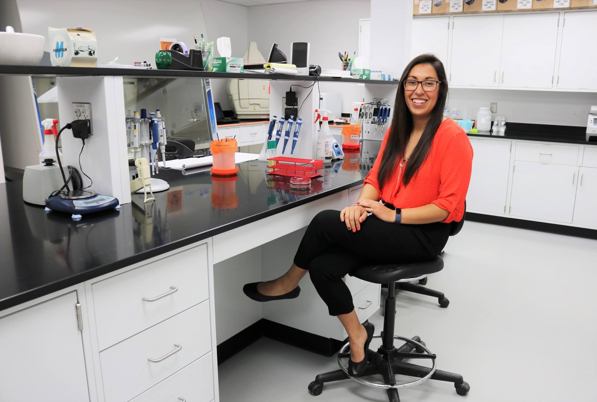 Erika Estrada sitting on a chair in a lab